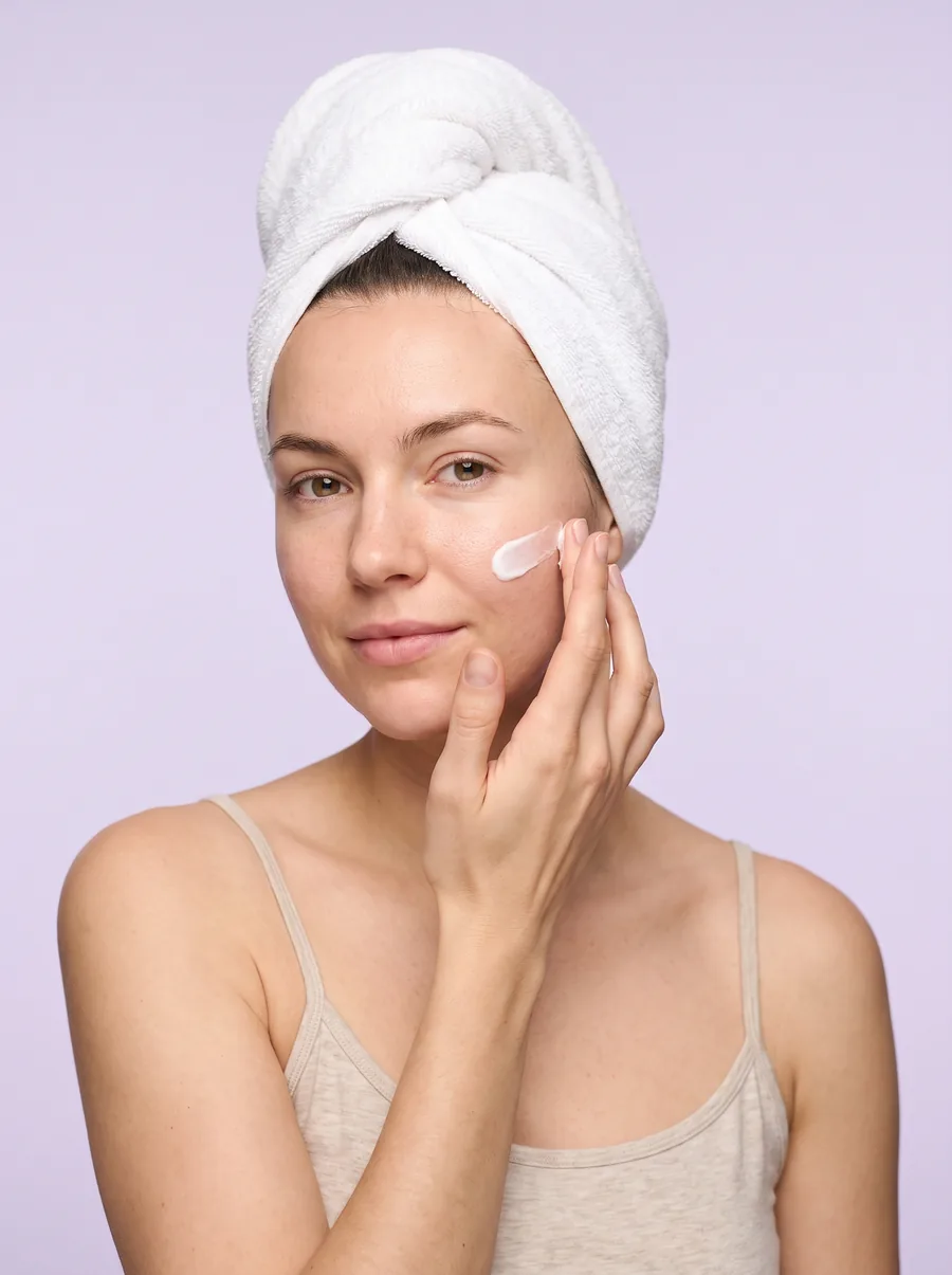 A woman applying moisturizer